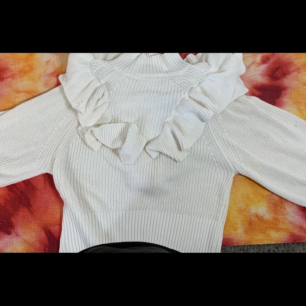 An off white ruffled sweater